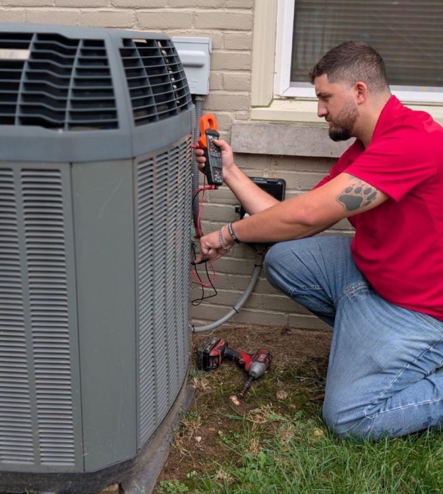 Lexington Electrical & HVAC technician testing an American Standard AC condenser beside a Lexington home.